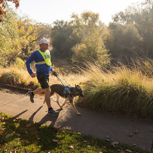 Blind runner runs on path with dog.